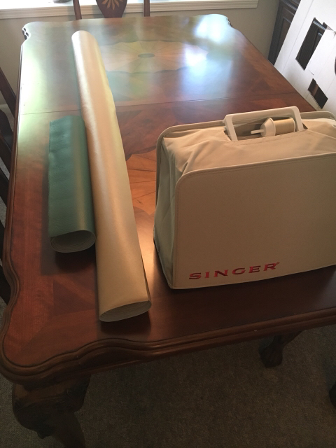 1996 Ford Bronco - Singer sewing machine case and two rolled tubes are on a wooden table.