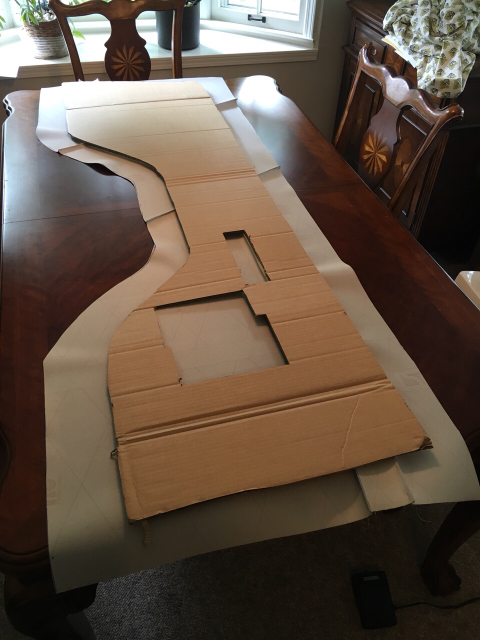 1996 Ford Bronco - A cardboard cutout is laid out on a wooden table, likely a template for a vehicle part.