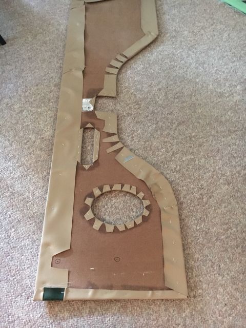1996 Ford Bronco - A cardboard template, likely for a car door panel, is shown on a carpeted floor.