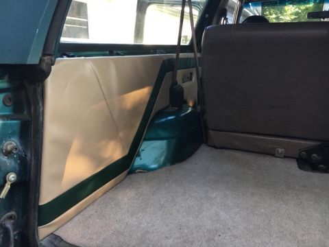 1996 Ford Bronco - The rear interior of a vehicle is shown, focusing on the cargo area's side panel and seat mounting.