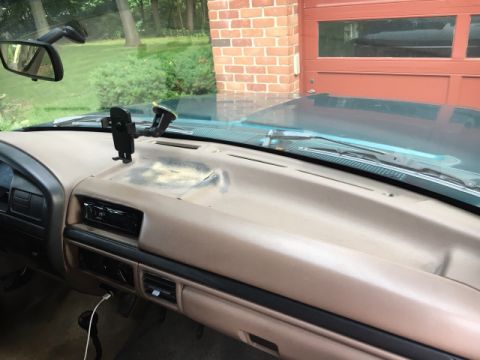 1996 Ford Bronco - The interior of a 1992 Ford Bronco shows a tan dashboard with an aftermarket stereo and a phone mount.