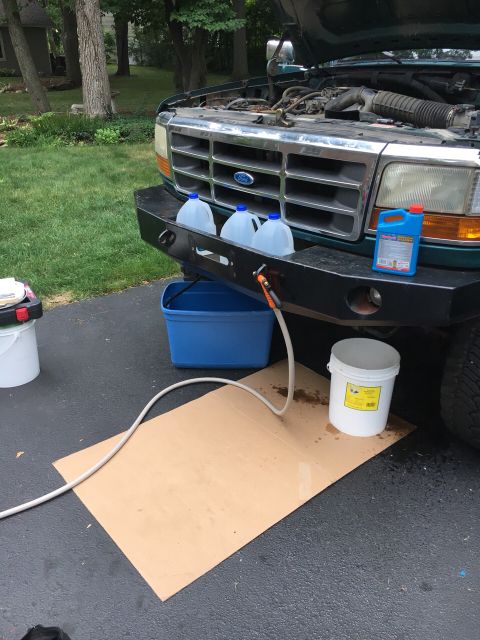 1996 Ford Bronco - Green Ford truck front view with hood open, showing a fluid change in progress. The grille suggests a 1995 model year.