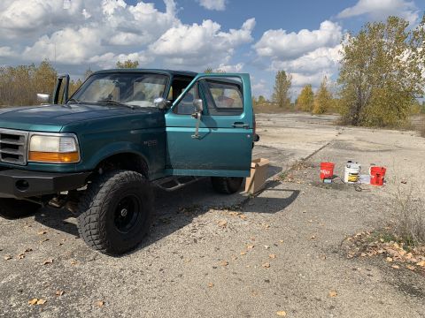 1996 Ford Bronco - Teal 1996 Ford Bronco parked outdoors with its doors open, showing aftermarket modifications.