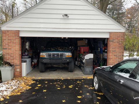 1996 Ford Bronco - A 1996 Ford Bronco is parked inside a garage, with a black car visible to its right.