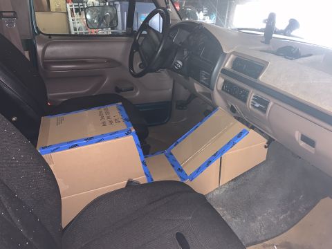 1996 Ford Bronco - Cardboard boxes secured with blue tape fill the passenger side of a vehicle's interior.