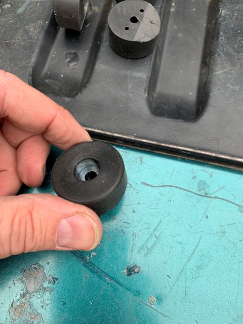 1996 Ford Bronco - A hand holds a rubber bumper part, with other similar parts visible in a black tray in the background.