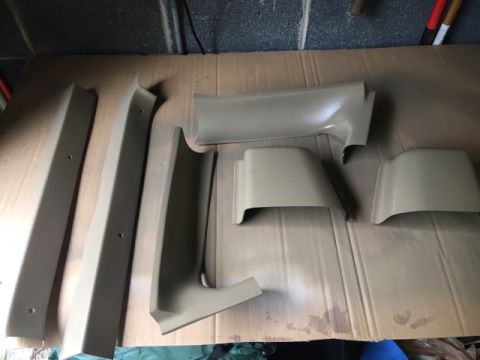 1996 Ford Bronco - Several tan interior trim pieces are arranged on a cardboard surface, possibly for painting or restoration.