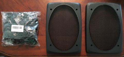 1996 Ford Bronco - Two black speaker grilles and a bag of assorted clips are displayed on a wooden surface, with a "Supermotors.net" watermark in the lower ri…