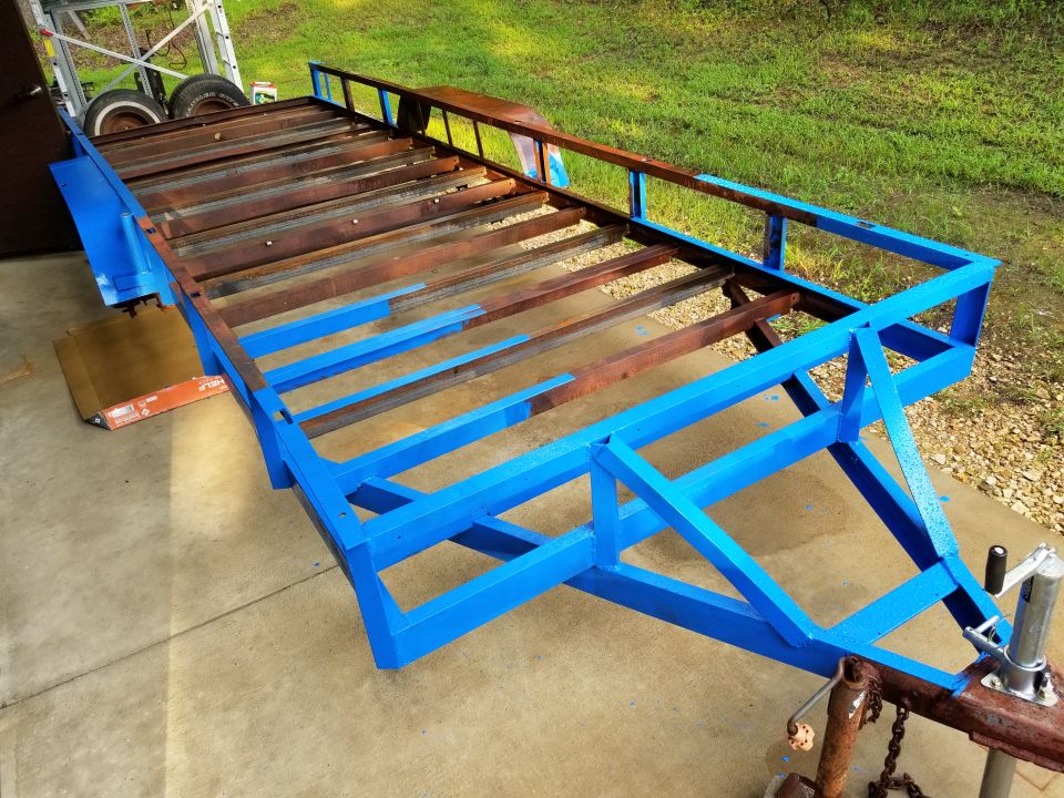 blue trailer frame with wooden slats and rusty metal supports