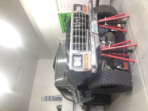 1979 Ford Bronco - A Ford Bronco is parked in a garage, supported by red jack stands.