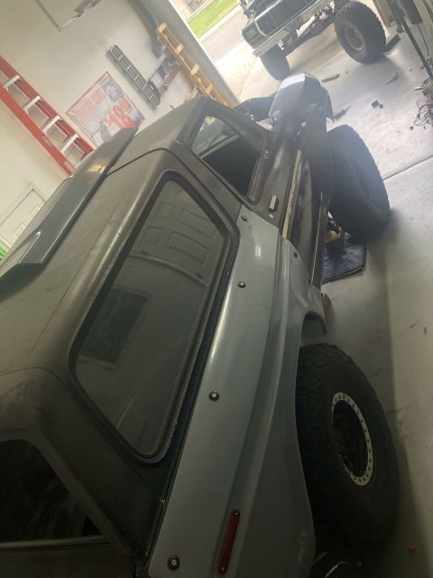 1979 Ford Bronco - A gray Ford Bronco is partially visible in a garage, with another vehicle in the background.