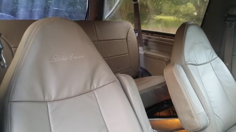 1995 Ford Bronco - Interior view of tan leather seats with embroidered "Eddie Bauer" script, showing the front and rear seating areas.