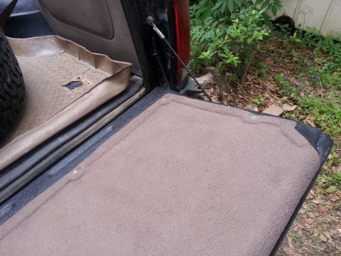 1995 Ford Bronco - Tailgate interior shows carpeted mat and spare tire.