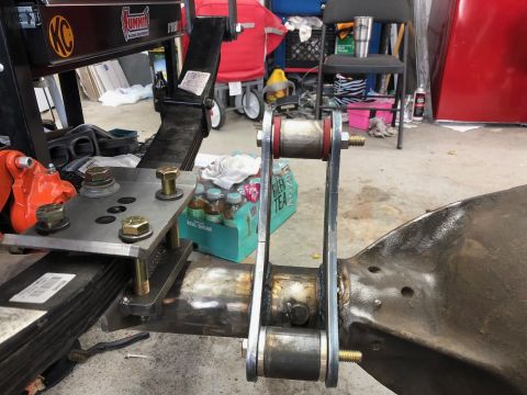 1992 Jeep Wrangler - A close-up view of a vehicle's suspension system, showing leaf springs, a U-bolt plate, and a shackle with bushings attached to the axle ho…