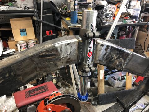 1992 Jeep Wrangler - A close-up view of a custom fabricated metal suspension component, possibly a frame reinforcement or steering component, with a Pro Fender…