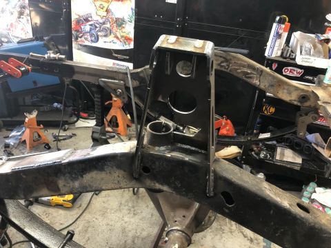 1992 Jeep Wrangler - A heavily modified Jeep Wrangler frame is shown in a workshop setting. The frame has been reinforced with welded metal plates and features…