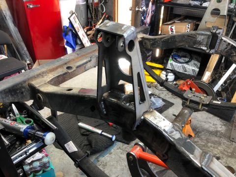 1992 Jeep Wrangler - The frame of a Jeep Wrangler is shown in a workshop setting, with visible modifications including newly welded brackets and leaf spring sus…