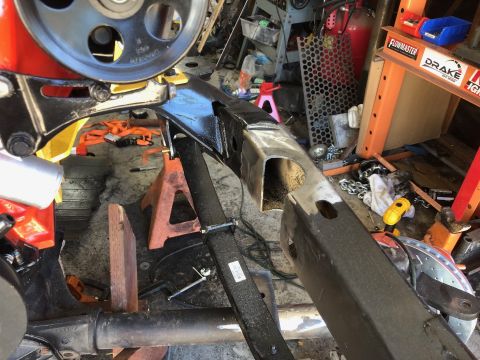 1992 Jeep Wrangler - A close-up view of a vehicle's frame and suspension components, possibly during a modification or repair. The scene appears to be a worksho…