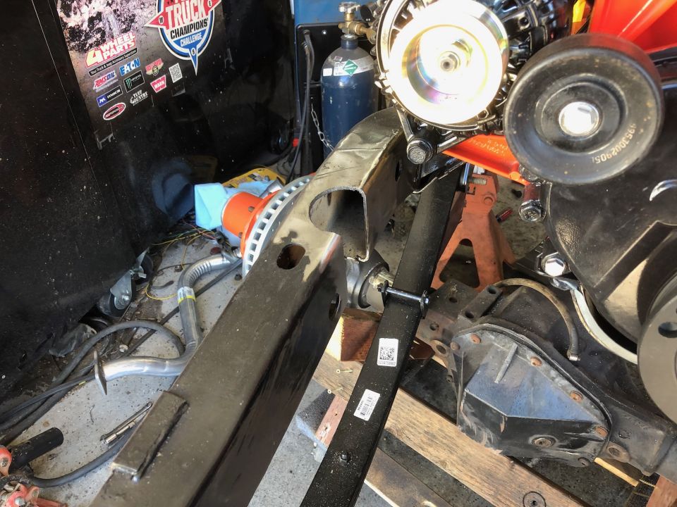 Vehicle chassis with engine, differential, and exhaust components.