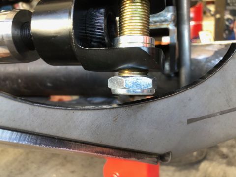 1992 Jeep Wrangler - A close-up view shows a bolt and nut assembly securing a black metal component to a gray metal bracket on a vehicle. The bolt has a gold-co…