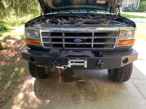 1996 Ford Bronco - Front view of a 1996 Ford Bronco with its hood open, an aftermarket bumper and winch.
