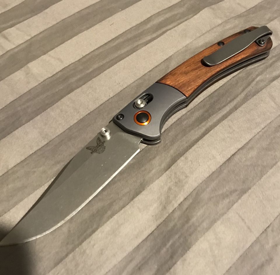 Folding knife with wood inlay on striped background
