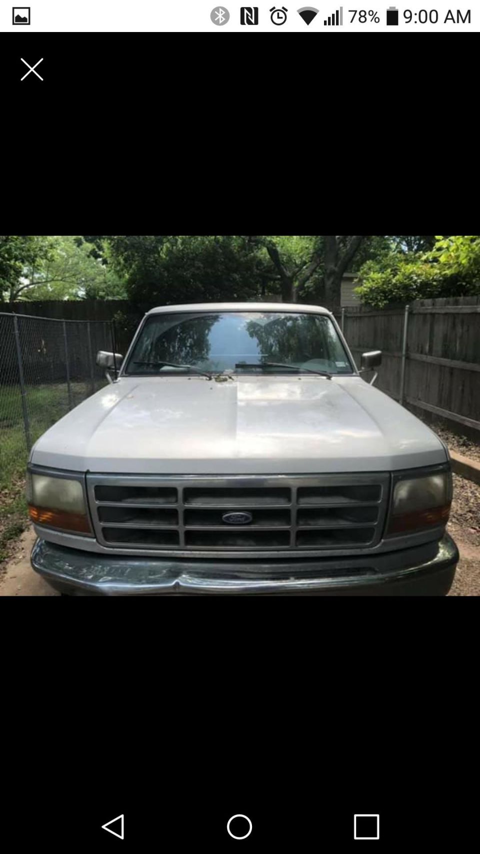 Front view of a white Ford pickup truck with a chrome grille and bumper.