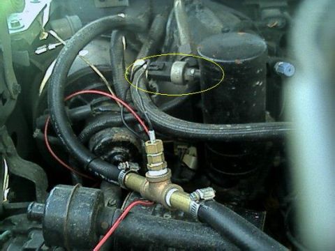 1989 Ford Bronco - Close-up view of engine bay components including hoses, wiring, and a sensor.