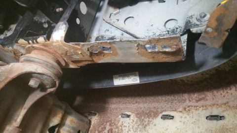 1996 Ford Bronco - A close-up view of a heavily rusted suspension component, a visible Ford part number label.