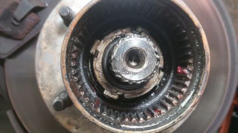 1996 Ford Bronco - This is a close-up view of a vehicle's wheel hub assembly, showing internal gears and grease.