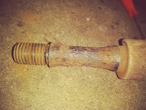 1996 Ford Bronco - Close-up of a heavily rusted suspension component, likely a bolt or stud, with visible threads.