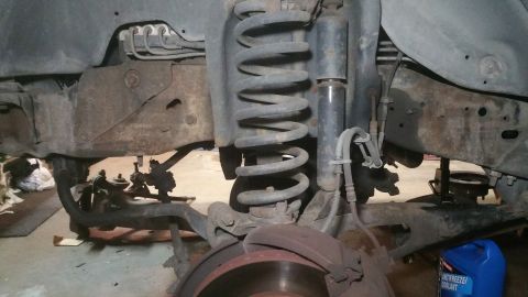 1996 Ford Bronco - Close-up view of vehicle front suspension parts during maintenance or repair.