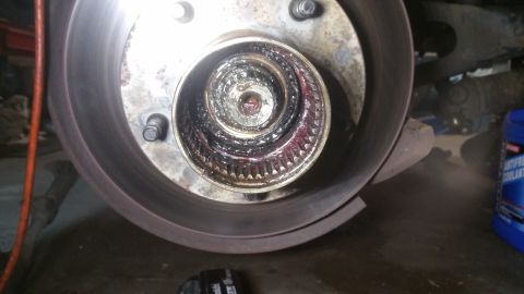 1996 Ford Bronco - Close-up of a greased wheel hub and brake rotor assembly, showing mechanical components.