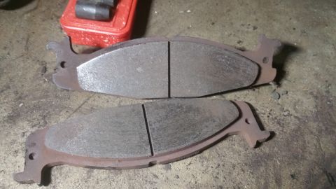 1996 Ford Bronco - Two brake pads are shown, likely for a vehicle's front suspension, with visible wear on the friction material.