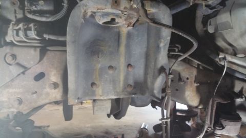 1996 Ford Bronco - Underside view of a vehicle's front suspension system, showing various metal parts and wiring.