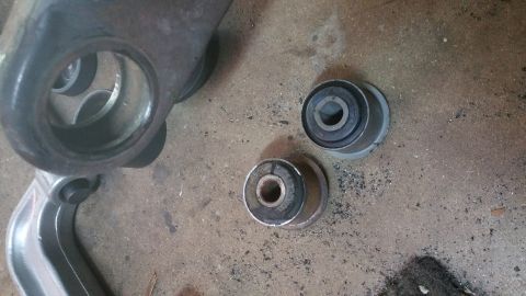 1996 Ford Bronco - Close-up of vehicle suspension components, including a metal control arm and rubber bushings.