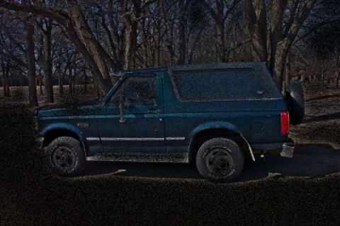 2003 Ford Bronco - Side view of a Ford Bronco SUV parked in a wooded area.