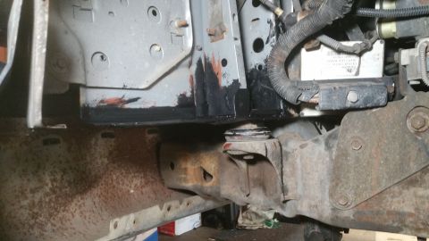 1996 Ford Bronco - Close-up view of vehicle front suspension parts, showing rust and black protective coating.
