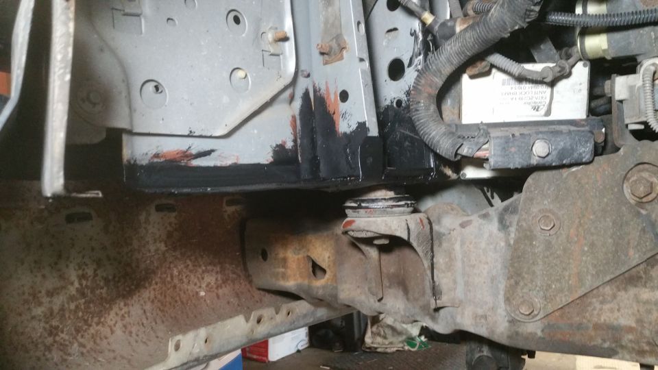 Rusty metal frame components with black coating and wiring harness