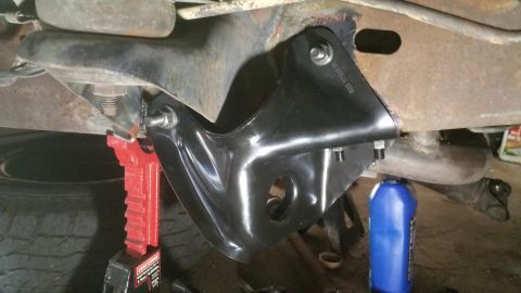 1996 Ford Bronco - Close-up of a vehicle's front suspension component being worked on, supported by jack stands.