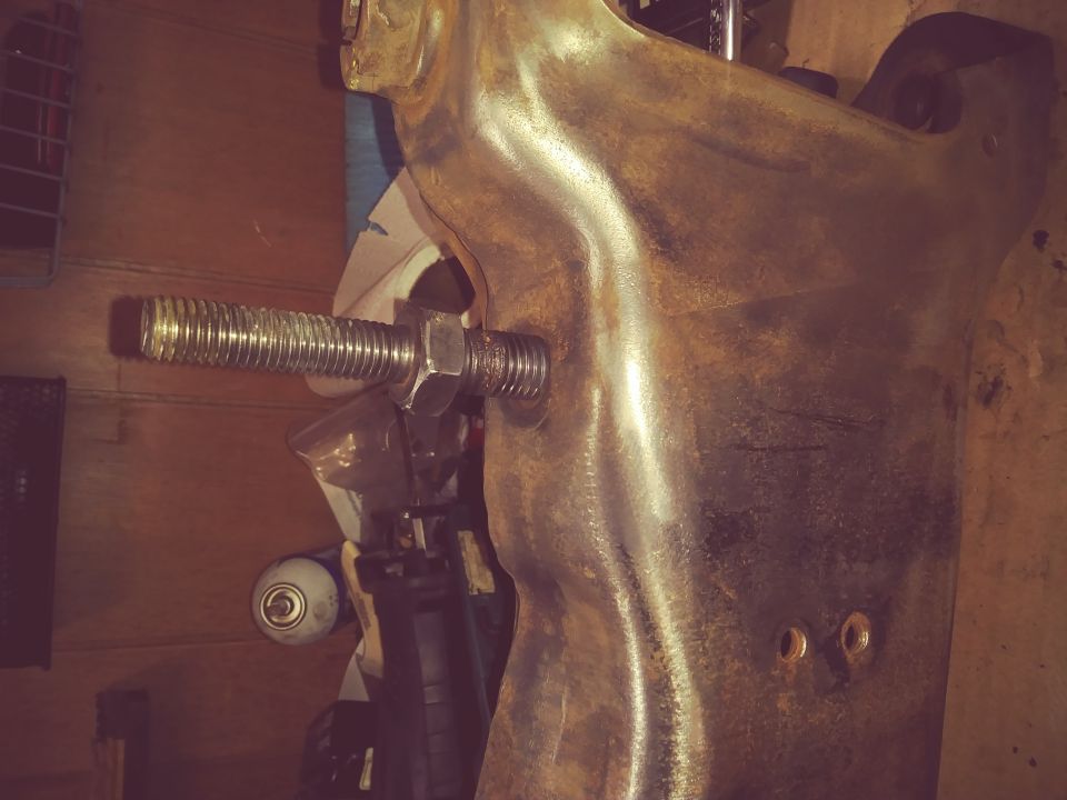 Close-up of a suspension component with a large bolt and nut