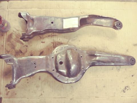 1996 Ford Bronco - Two automotive suspension parts, likely from the front and rear, are shown on a flat surface.