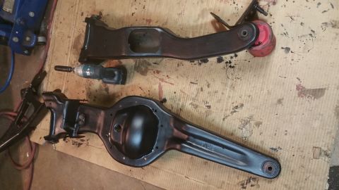 1996 Ford Bronco - Differential and suspension parts laid out on a surface with a drill and jack visible.