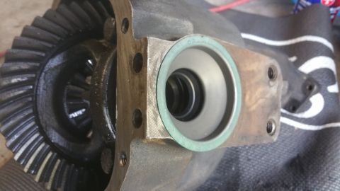 1996 Ford Bronco - Close-up of a differential gear assembly, revealing the internal gears and a green gasket seal on the housing.