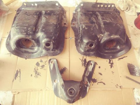 1996 Ford Bronco - Two large and one smaller automotive suspension parts laid out on cardboard for inspection or repair.