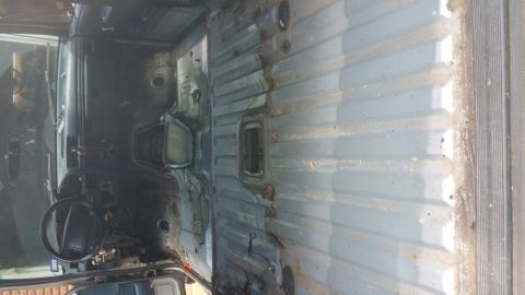 1996 Ford Bronco - The interior of a vehicle shows exposed metal and a steering wheel, suggesting it has been stripped down.