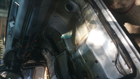 1996 Ford Bronco - Interior of a vehicle undergoing disassembly, revealing structural components and wiring.