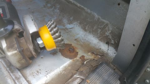 1996 Ford Bronco - Wire wheel on angle grinder removes rust from the interior floor of a vehicle.