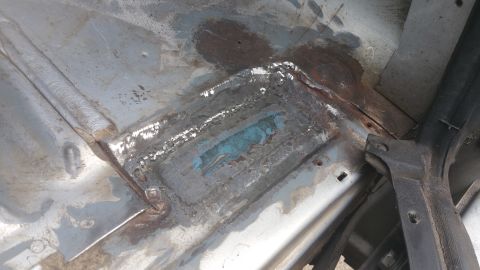 1996 Ford Bronco - This image shows a section of a vehicle's floor that has been patched and shows signs of rust.