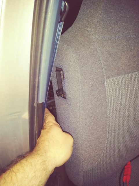 1996 Ford Bronco - Interior view of a car seat and door frame, with a hand reaching into the crevice.